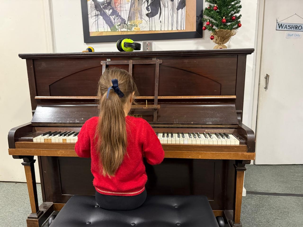 Anita playing an upright piano