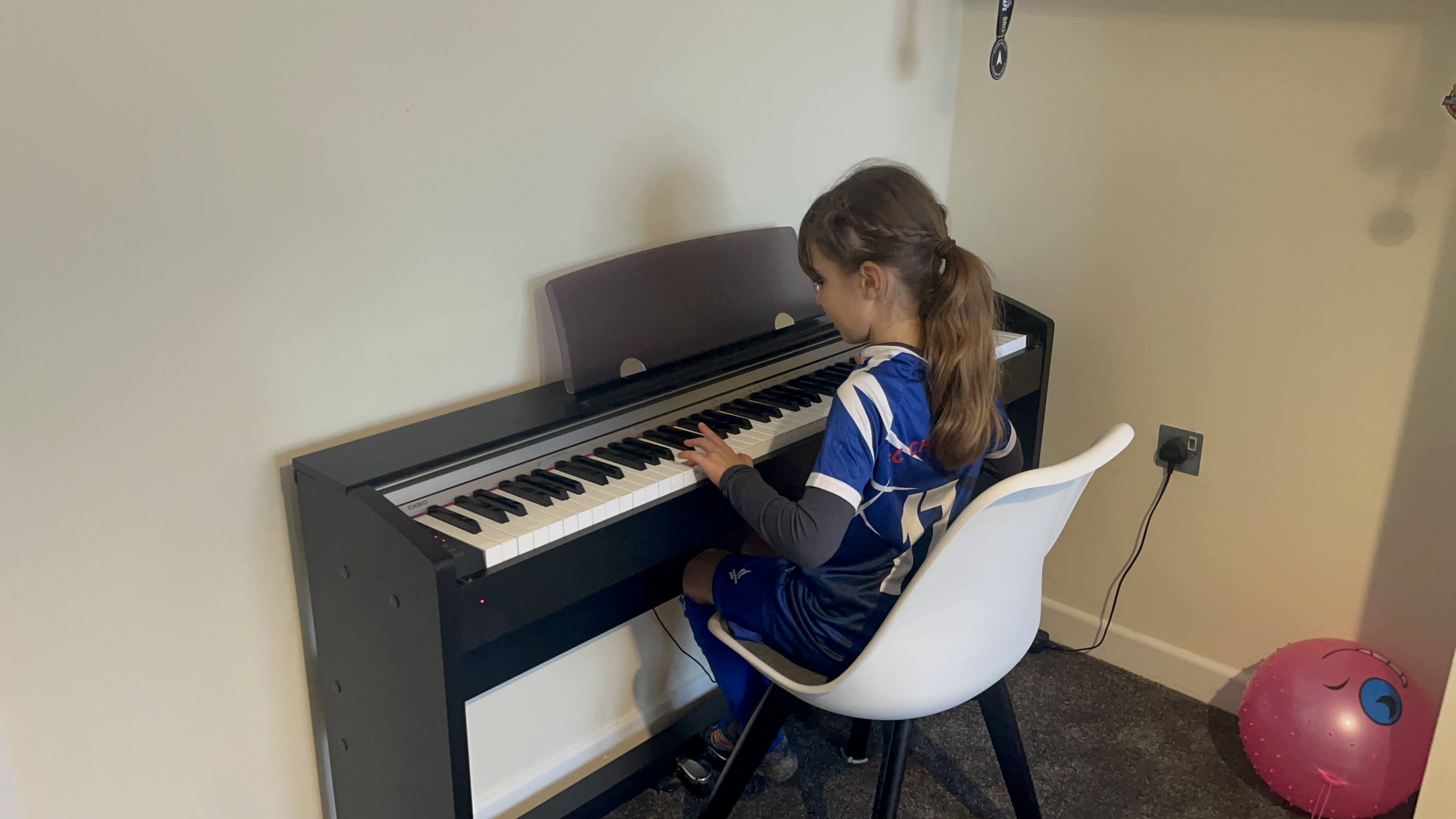 Child enjoying a piano lesson at home